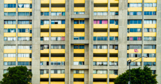 Concrete apartment building with striking yellow balconies in Mexico City, showcasing urban residential life.