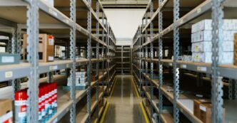 Wide view of an organized industrial warehouse with metal shelving and stored merchandise.