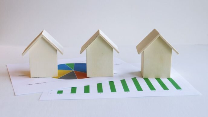 Wooden model houses on graphs depict real estate market analysis and trends.