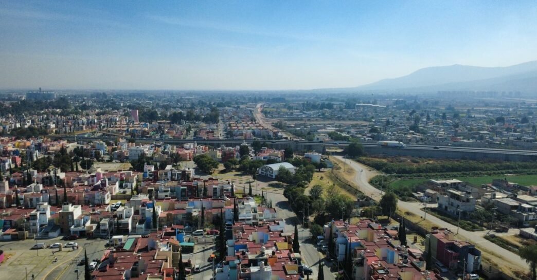 A panoramic aerial view of Tultepec, Estado de México, showcasing urban sprawl against a mountainous backdrop.