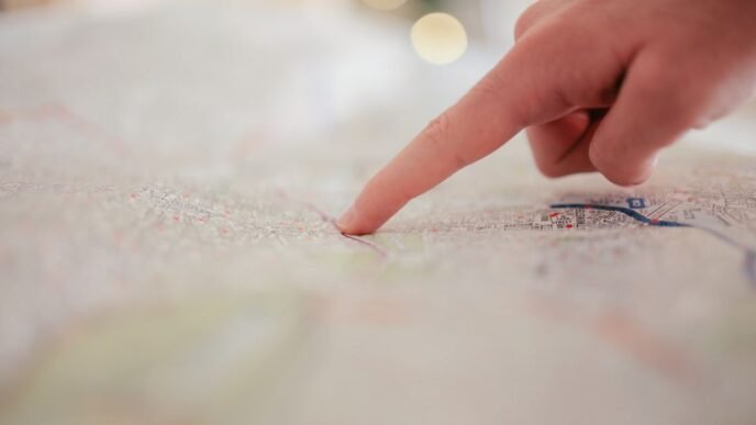 A hand pointing at a city map, highlighting direction and navigation planning.